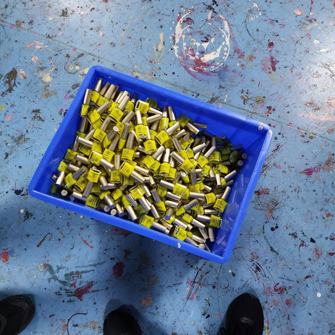 Neon yellow glow in the dark nail polish bottles in a production crate